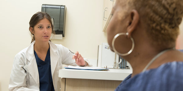 Doctor consulting with patient about how to use cbd oil for pain. What is the best cbd oil for pain? How to use cbd oil for back pain.
